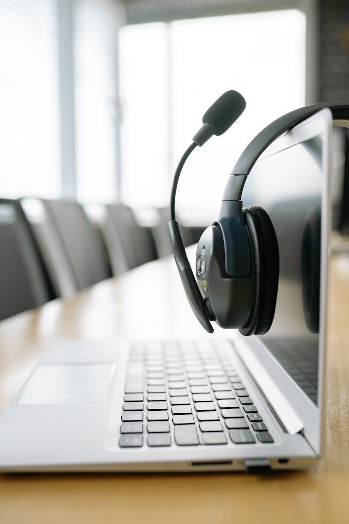 gallery-06 A modern laptop paired with a headset on a desk, ideal for virtual meetings or online communication.